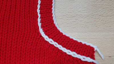 Machine Knit Neckbands: Jazz em Up! Close-up of a machine-knitted neckband showing decorative detail where the band meets the garment, demonstrating how to add visual interest to traditional band edges.