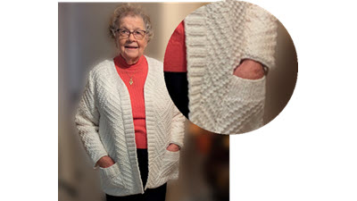 Never Give Up: How Carolyn Conquered Her Sweater Challenge Carolyn wearing her completed tuck stitch sweater, with close-up views showing the hand-knit ribbed button band and pocket detail. The modern design features clean, ribbing-free hems