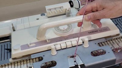 Brother KH260 Bulky Knitting Machine Brother KH260 bulky knitting machine carriage threaded with yarn, showing the 9mm needle spacing