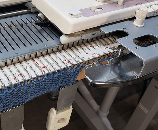 Knitting machine setup: carriage on the right side for specific techniques Knitting machine with carriage positioned on the right