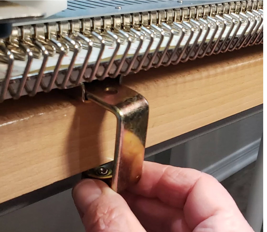 Clamp for securing the main bed of a knitting machine to a table